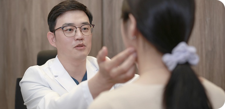 안면거상 재수술 상담에서 이전 부작용의 원인을 살피는 모습